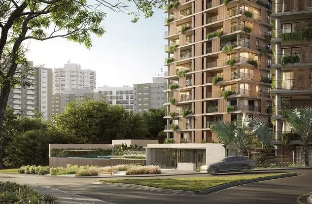 Vista externa da fachada do edifício com vegetação nos pavimentos e entrada arborizada.